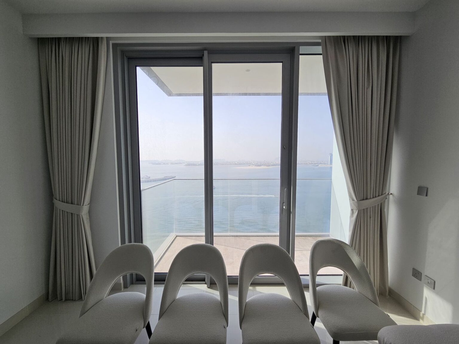 Blackout curtains in a Palm Jumeirah Dubai apartment with sea view — beige pleated drapes installed by Best Curtain in Dubai (BCD)